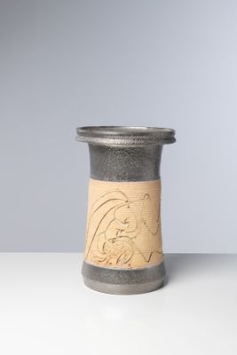 un petit vase orné d'un motif, posé sur une table