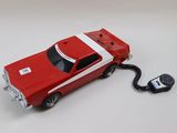 une petite voiture reliée à une télécommande