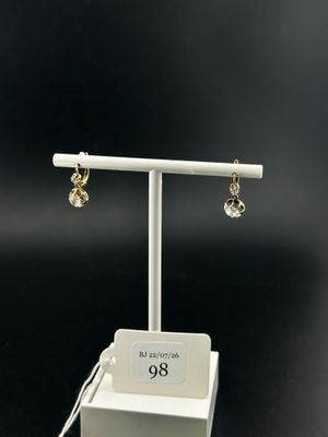 a pair of earrings on a stand with a price tag