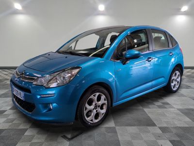 une voiture bleue est garée dans une pièce au sol à carreaux