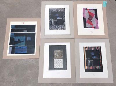 quatre tableaux encadrés représentant différents types d'œuvres d'art, posés sur une table