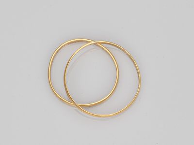 une paire de boucles d'oreilles en or sur fond blanc
