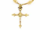 un gros plan d'un collier orné d'une croix sur fond blanc