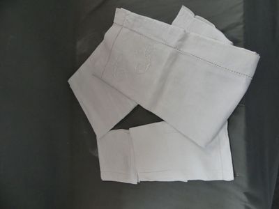 une pile de serviettes blanches pliées sur un canapé noir