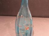 a blue glass vase sitting on a white table