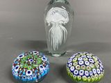 three glass vases sitting on top of a table next to each other