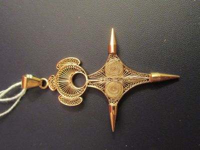 a gold scissors that is on top of a black table