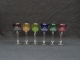 six wine glasses are lined up in a row on a black background