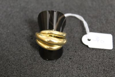 a black and gold ring with a white tag on it