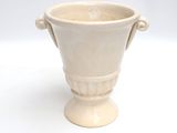 un vase blanc posé sur une surface blanche