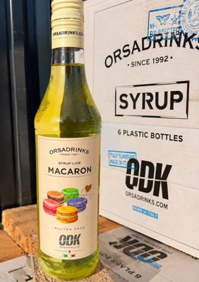 a bottle of macaron sitting on a table next to a box of drinks