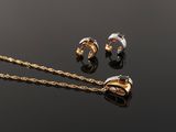 two pieces of jewelry sitting on top of a table next to each other