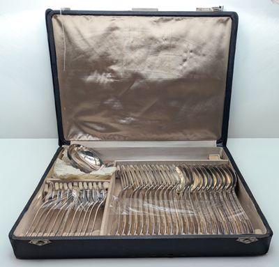 un coffret noir contenant de l'argenterie, posé sur une table