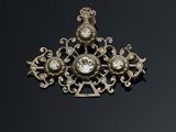 une broche ancienne en argent et diamants posée sur un fond noir