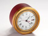 une horloge rouge et dorée avec des chiffres romains