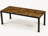 La table est en bois et en métal et présente un motif.