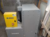 une machine qui se trouve dans une pièce, à côté d'un tas de bois