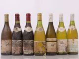 six bouteilles de vin sont alignées sur une surface blanche