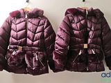 deux vestes violettes accrochées à un mur, avec un mur blanc en arrière-plan