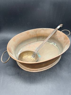 a brown bowl with a spoon in it on a table