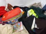 a pile of clothes and toys on a bed