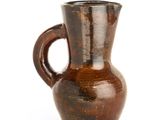 a brown vase with a handle on a white background