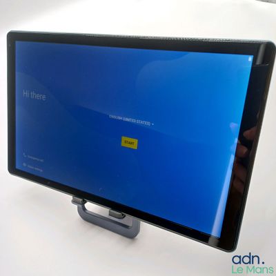 someone is holding a tablet with a blue screen on top of it