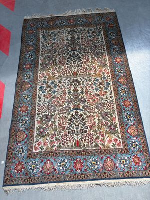 un tapis oriental posé à même le sol dans une pièce recouverte d'une moquette rouge