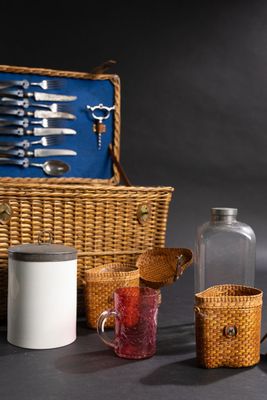 un panier en osier contenant de l'argenterie et un bocal en verre
