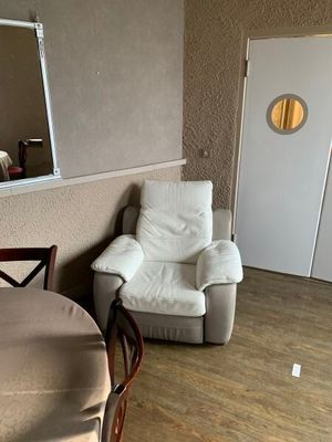 une chaise et une table dans une pièce où il y a un miroir accroché au mur