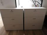 pair of white dressers in a room with wooden flooring