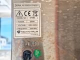 a close up of a metal object with a green button on it