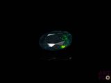 un gros plan d'un diamant vert et noir sur une surface noire