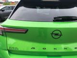 a green car parked in a parking lot with other cars in the background
