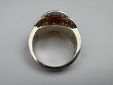 a close up of a silver ring with a red stone in it