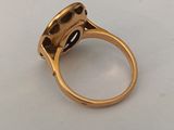 a close up of a gold ring with a black stone in it