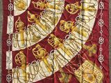 a close up of a red and gold scarf on a carpet