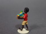 a small figurine of a boy carrying a basket of fruit