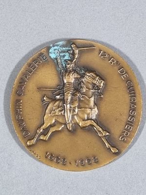 a gold medal with a man on a horse holding a flag