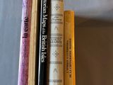 trois livres sont empilés les uns sur les autres sur un lit