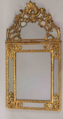 gold framed mirror with ornate design on a white wall