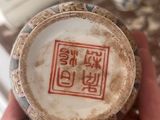 a person holding a vase with a chinese writing on it