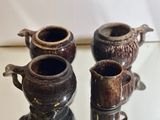 three brown vases sitting on a glass table
