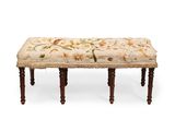 un banc rembourré sur lequel repose un coussin à motifs floraux