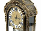 a gold clock with a bird on top of it