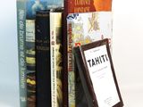 several books are stacked on top of each other on a white surface