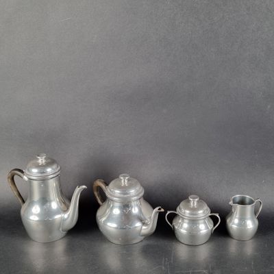 trois théières en argent et une cafetière posées sur une table