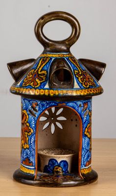 an image of a blue and yellow ceramic candle holder on a wooden table