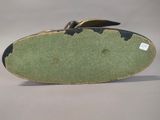 a green and black shoe with a gold shoe hook