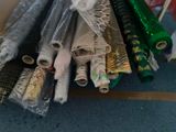 many rolls of fabric sitting on the floor next to each other